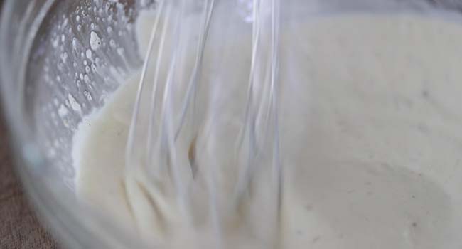 whisking a creamy vinaigrette