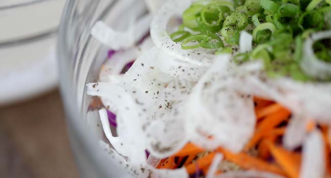 seasoning coleslaw in a bowl