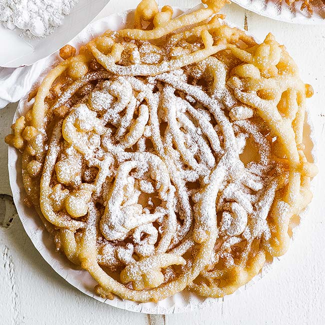 plate of funnel cake with powdered sugar
