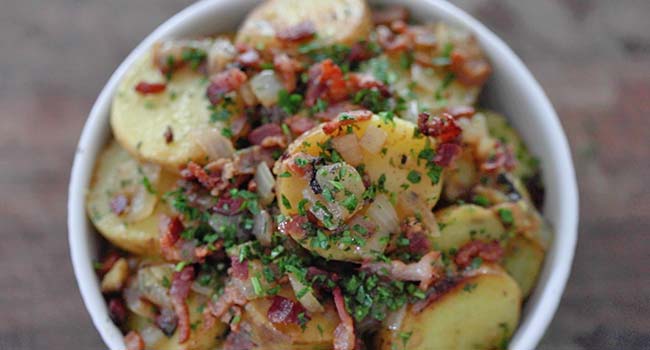 garnishing german potato salad with parsley