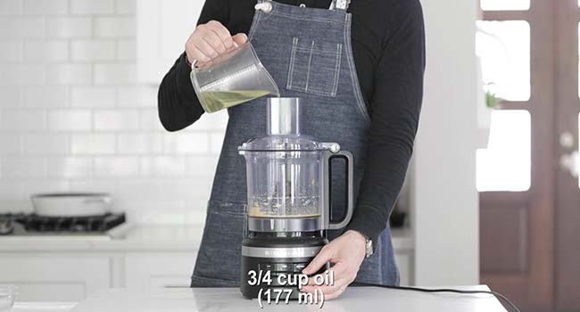 drizzling oil into a food processor with egg yolks