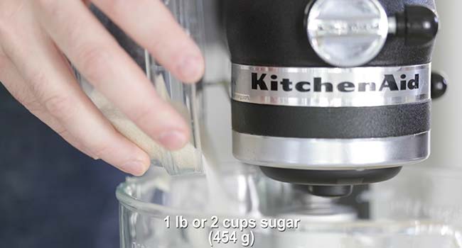 adding sugar to a stand mixer