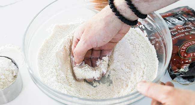 making a well from flour with the back of a hand