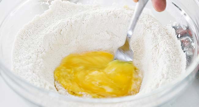whisking eggs and lemon zest with flour