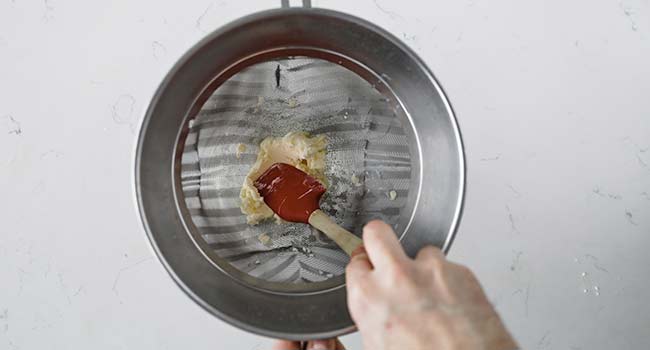 pressing butter in a chinois