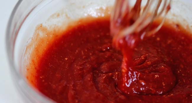 whisking together a cocktail sauce in a bowl