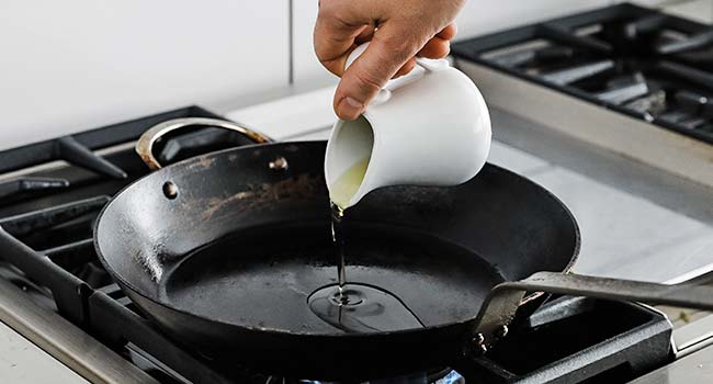 adding clarified butter to a hot saute pan