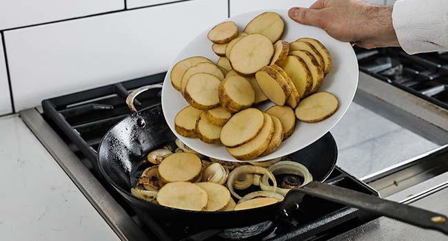 adding the sliced potatoes to a pan with caramelized onions