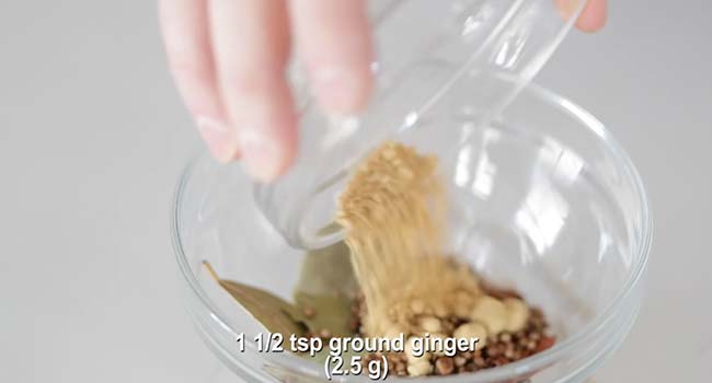 adding ginger to a jar with spices