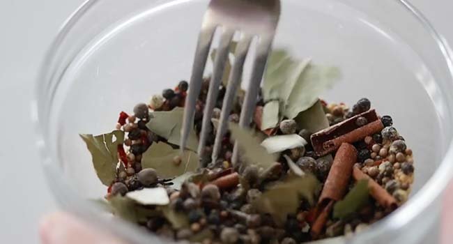 mixing together a bowl of pickling spice spices