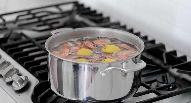 boiling shrimp in a pot with lemons