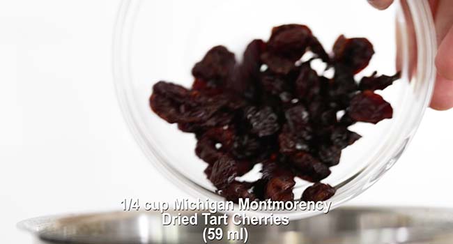adding dried cherries to a pot