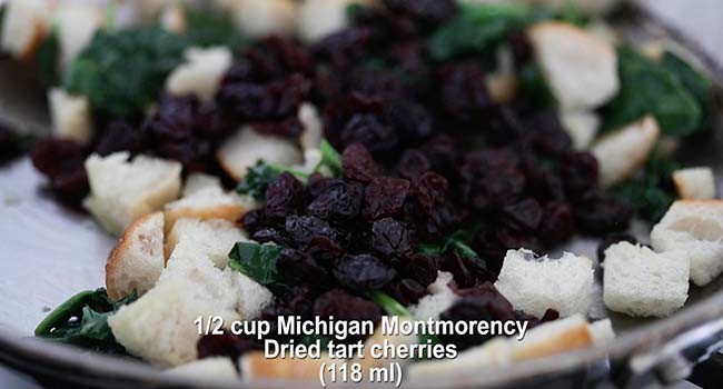 adding dried cherries and sourdough to a pan