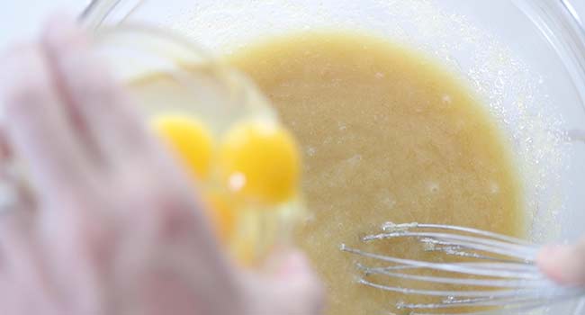 adding eggs to a zucchini bread batter