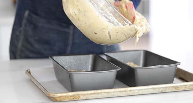 pouring zucchini bread batter into loaf pans