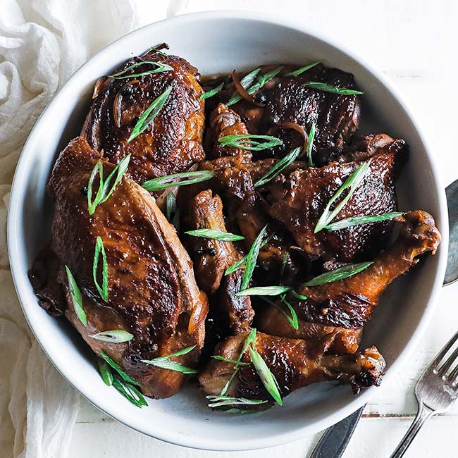 bowl of chicken adobo with green onions