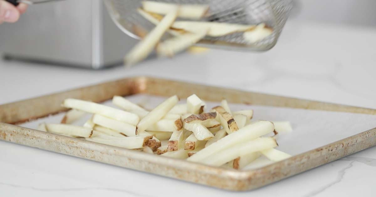 adding pre blanched french fries to a pan