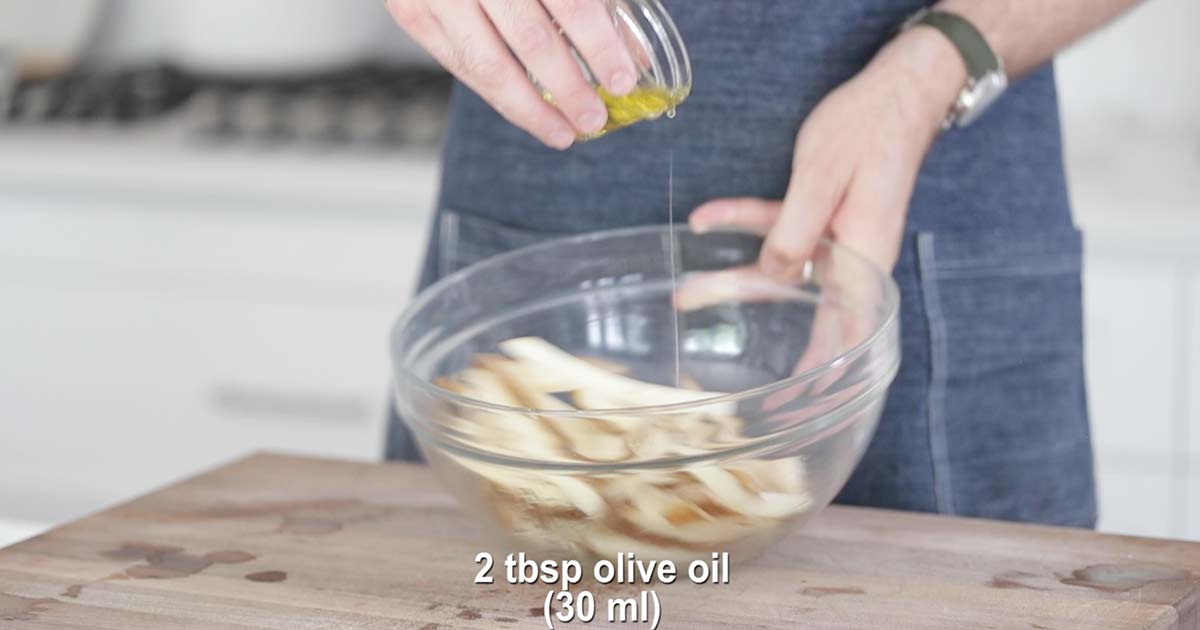 coating sliced potatoes in olive oil