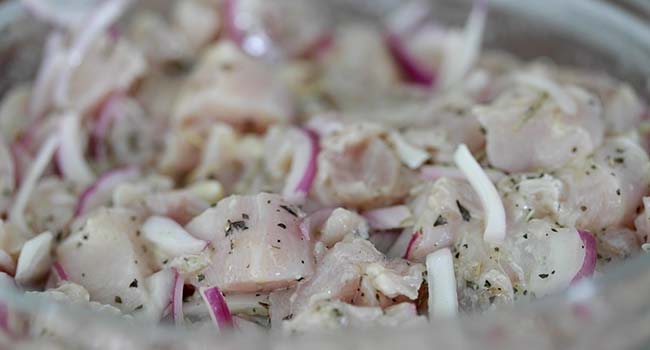 adding seasonings to chicken in a bowl