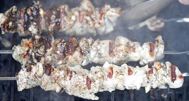 grilling chicken kebabs on a grill