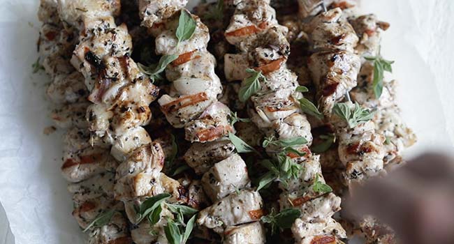 garnishing chicken souvlaki kebabs