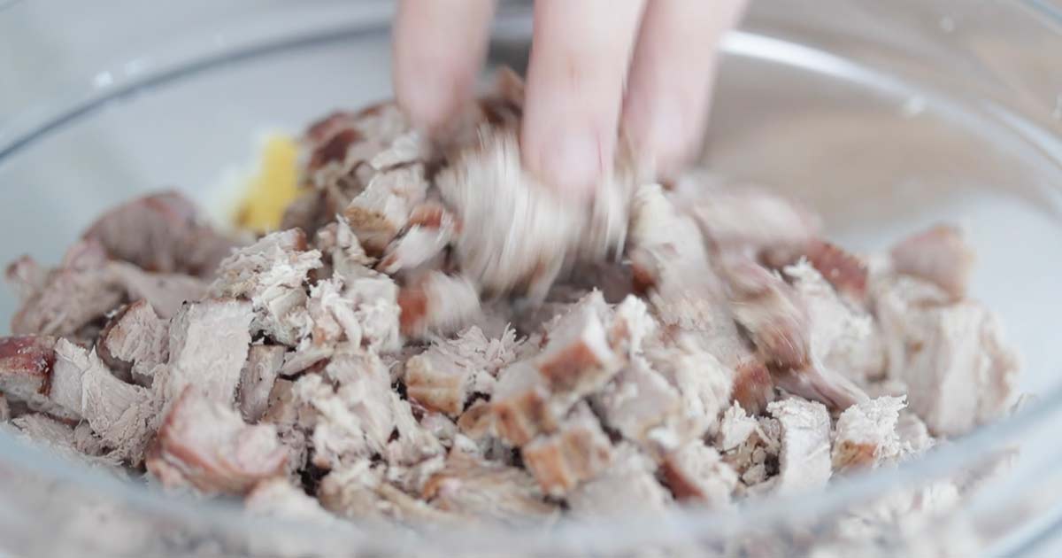 adding fresh cooked tuna to a bowl