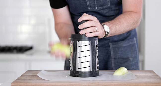 shredding a peeled cucumber