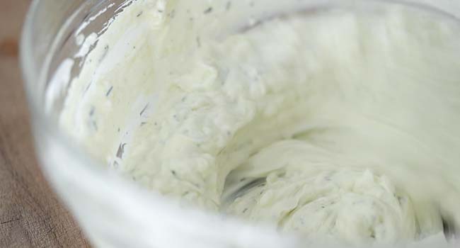 whisking together tzatziki ingredients in a bowl