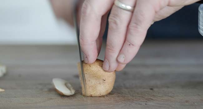 slicing a baby portabella mushroom