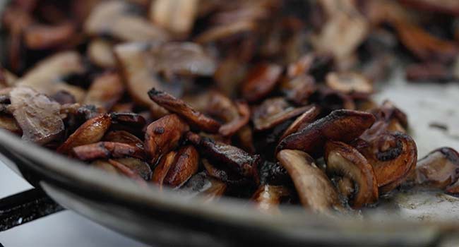 sautéing mushrooms in a pan