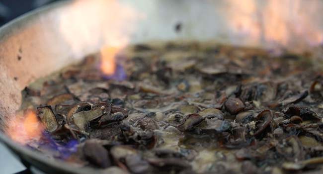 deglazing a pan of mushrooms with sherry wine