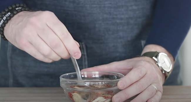 mixing together cajun seasoning blend in a bowl