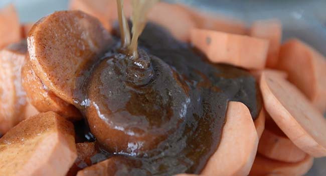 pouring caramel sauce over sweet potatoes