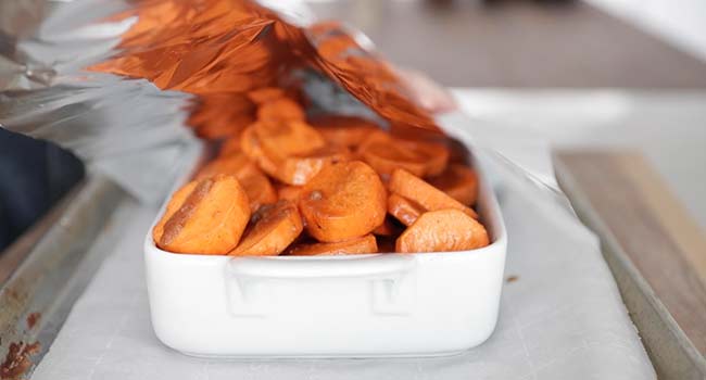 adding candied yams to a casserole dish