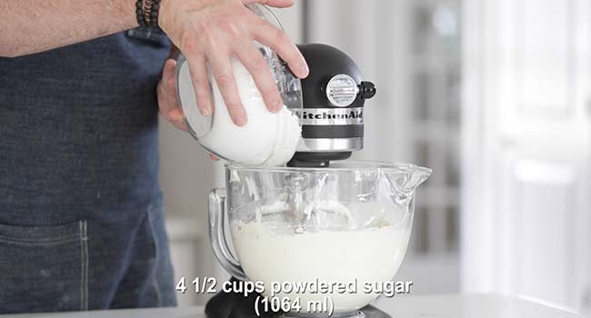 adding powdered sugar to whipped cream cheese