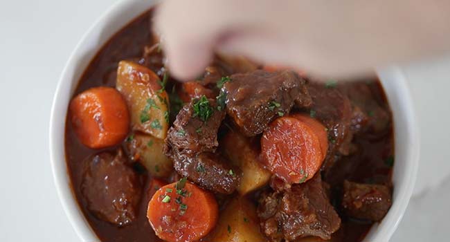 garnishing Hungarian goulash with parsley