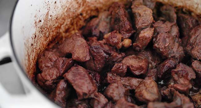 browning off chunks of beef shank in rendered bacon fat