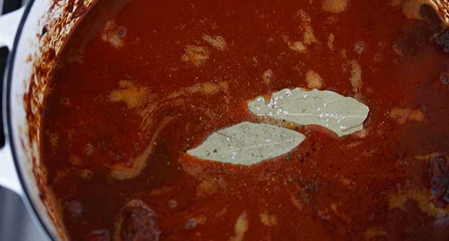 simmering beef in beef stock with bay leaves