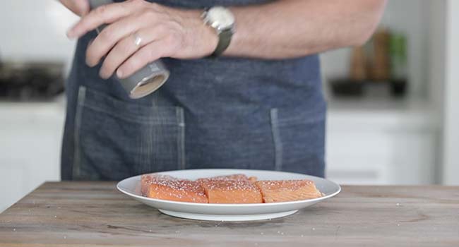 seasoning salmon fillets with salt and pepper