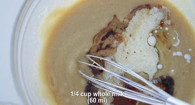 adding milk to a pumpkin bread batter