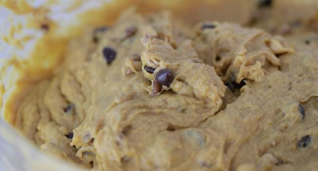 adding pumpkin bread batter to loaf pans