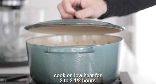 adding a lid to a pot of red beans