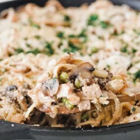 taking a scoop out of a pan with turkey tetrazzini