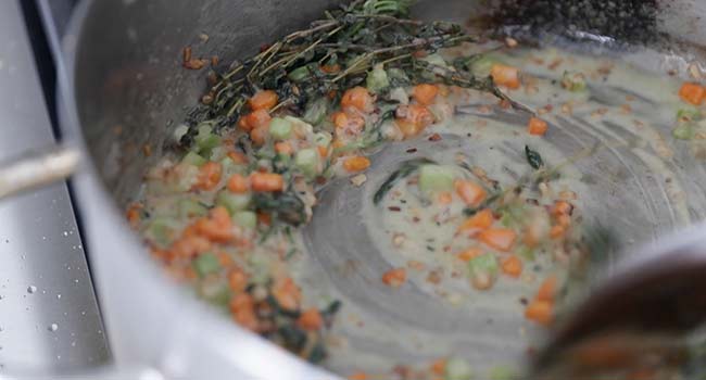 making a roux with flour and cooked vegetables