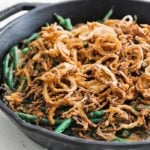 green beans with onion straws in a cast iron skillet