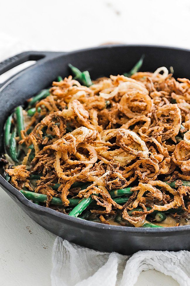 green beans with onion straws in a cast iron skillet