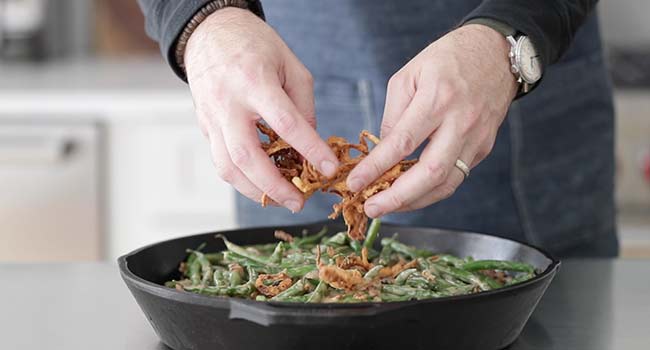 adding fried onion straws to green bean casserole