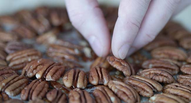 adding pecans to a pecan pie