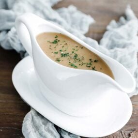 gravy boat full of turkey gravy with herbs