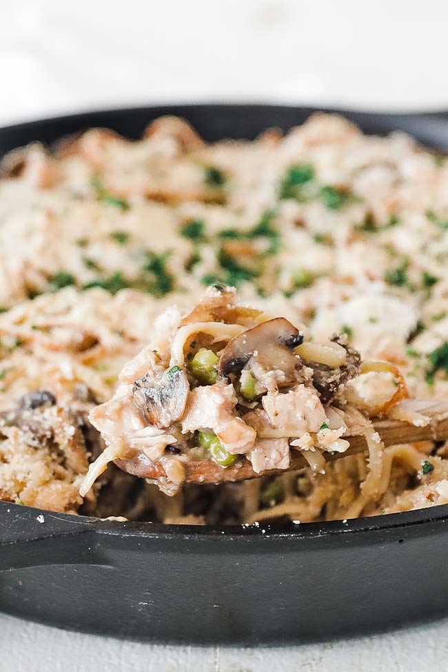 taking a scoop out of a pan with turkey tetrazzini